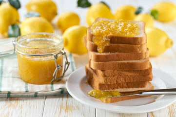 A stack of toasts with lemon jam on a dish close-up. Plate with pieces of toasted bread and tasty lemon jam.