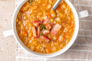 Top view oa a bowl with Creamy yellow split pea soup with smoked bacon, ham. Homemade comfort food.