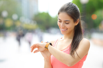 Happy runner checking time on smartwatch