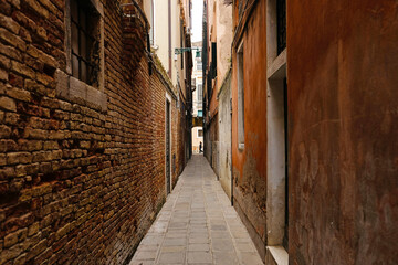 Typical narrow street with historical houses in Venice. Narrow pedestrian streets of Venice between the channels. 