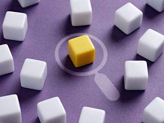 Magnifying glass analyzes the yellow colored cube surrounded by white cubes.