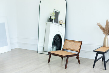 Stylish Skandi and minimalistic composition at living white room interior with design rattan...