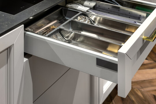 Metal kitchen drawer organizer in wood kitchen with simple set of kitchen tools, furniture details