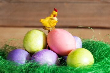 Fototapeta na wymiar Row of colorful Easter eggs and yellow chicken decoration on wooden background, copy space