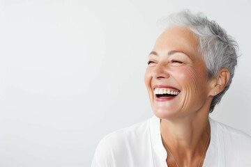 Elderly woman smiling widely with silver hair against her white wall background. Ai generated - obrazy, fototapety, plakaty