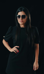 
Latina model posing with designer sunglasses on black background