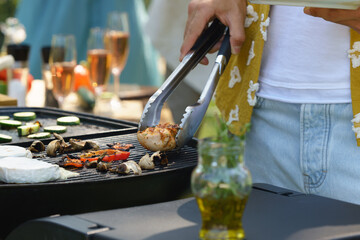 Meat and vegetables grilling on outdoor grill. Outdoor grill or BBQ party in the garden.