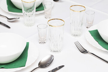 White tablecloth restaurant. Silverware cutlery background. Empty dishware prepared for dinner. Plates and soup bowls. Catering set. Party banquet eating and drinking. Lunch table. Glasses and napkins