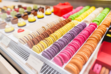 Close-up view of colorful macarons and other sweets on counter display in a bakery