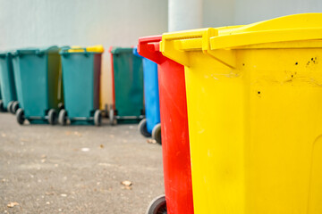 Close-up on several multi-colored plastic waste sorting baskets in the office backyard, recycling and sorting garbage, environmental responsibility