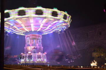 fast spinning carousel with pink and purple lights
