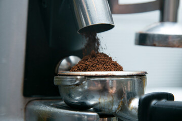 Professional barista working with a coffee machine and preparing hot drinks with coffee and milk.