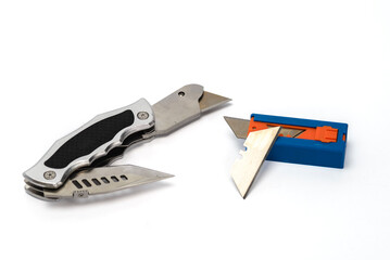 Razor type cutting tool with sharp blade and replacement blades on white background.