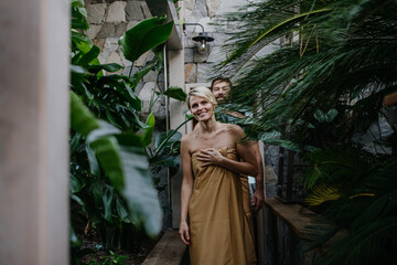 Beautiful couple standing in hotel greenhouse,enjoying romantic wellness weekend in spa. Concept of...