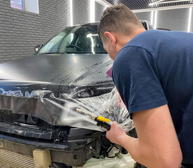 Car wrapping. A car wrapping specialist applies a polyurethane film to the car. Selective focus....