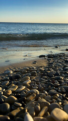 Sea rocks on the seashore. Blue sea and sand. A photo of the stones.