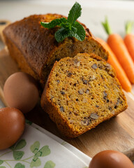 Delicious and fluffy carrot cake with walnuts on a wooden board.