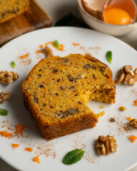 Delicious and fluffy carrot cake with walnuts on a wooden board.