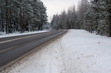 Obraz premium Winter road through forest in Hallsberg Sweden