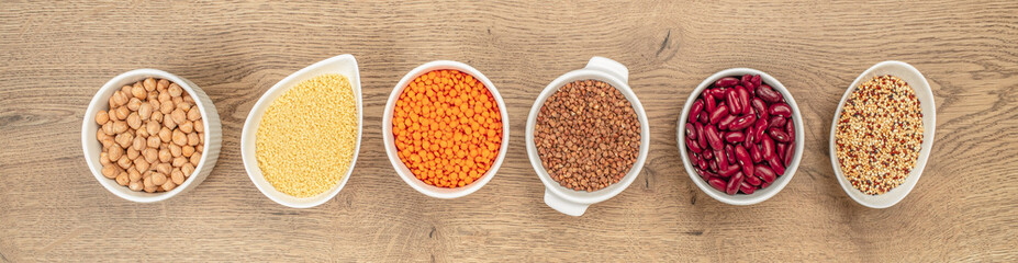 gluten free grains chickpeas, couscous, lentils, buckwheat, beans, quinoa in bowl. Long banner...