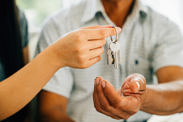 A cheerful couple displays keys to their new house symbolizing happiness and success in their real...