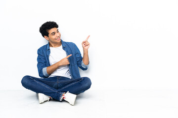 Venezuelan man sitting on the floor pointing with the index finger a great idea