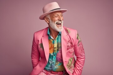 Portrait of a stylish senior man posing in a pink suit and hat.