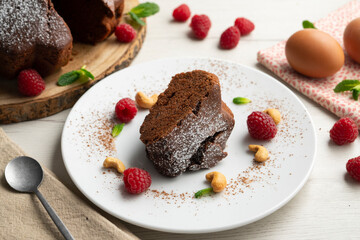 Delicious and fluffy round chocolate cake with cashews and raspberries.