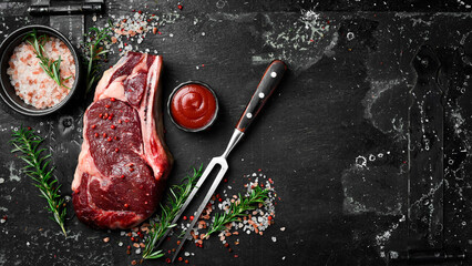 Raw steak. Beef steak with metal fork and seasonings on a wooden board, top view.