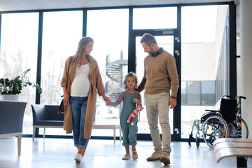 Girl patient at examination in a modern clinic. Girl arriving in hospital with her parents. Emotional support during medical examination.