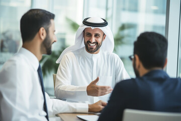 Saudi successful business people in traditional Kandura meeting and talking at office desk. Saudi, Emirati, Arab businessman. - obrazy, fototapety, plakaty