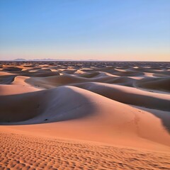 Fototapeta na wymiar A vast desert expanse under a clear blue sky, with sand dunes stretching to the horizon and sparse vegetation clinging to life in the arid landscape Free ai genareted image download...