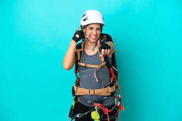 Young Italian rock-climber woman isolated on blue background making phone gesture and pointing front