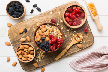Cooking a wholesome breakfast. Granola with Various dried fruits and nuts in a bowl. The concept of a healthy dessert. Flat lay, top view with copy space