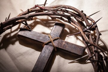 Christian cross with crown thorns on gray desk.