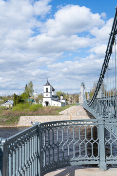 Chain bridge over the river Velikaya and church of St. Nicholas in the old town of Ostrov, Pskov region, Russia