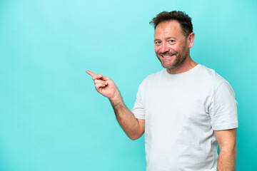 Middle age caucasian man isolated on blue background pointing finger to the side