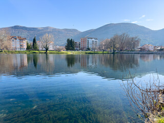 Fototapeta premium Multi-storey houses on the shore of the lake and against the mountain