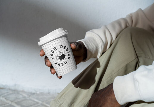 Mockup of man holding disposable cup, customizable