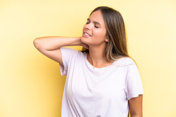 Obraz premium Young caucasian woman isolated on yellow background with neckache
