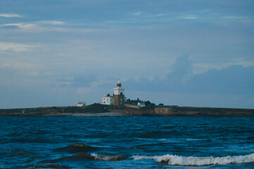 stormy sea with an island with lighthouse