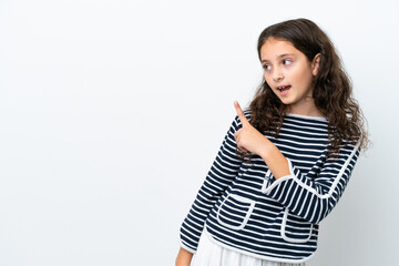 Obraz premium Little caucasian girl isolated on white background surprised and pointing side