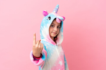 Little caucasian woman wearing a unicorn pajama isolated on pink background doing coming gesture