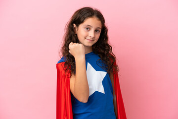 Little caucasian girl isolated on pink background in superhero costume