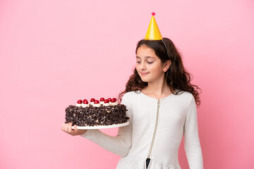 Little caucasian girl holding birthday cake isolated on pink background with happy expression