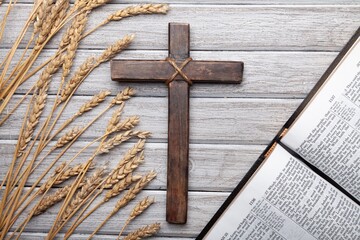 Wood cross and golden wheat on desk