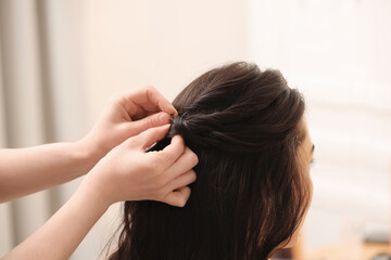 Hair styling. Professional hairdresser working with client indoors, closeup