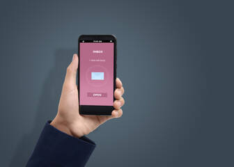 Got new message. Man holding smartphone on grey background, closeup. Space for text