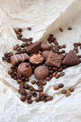 fine chocolate candies and coffee beans close up on paper background. Assortment of chocolate sweets, tasty milk chocolate.