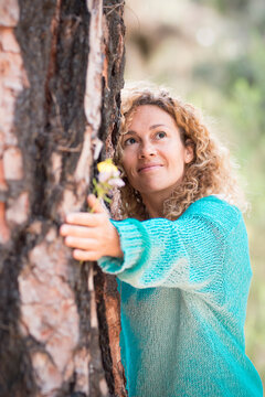 People and save nature concept with woman hugging a tree with love and care - save the planet and climate change global warmin worried problem - beautiful female and big pine in the forest